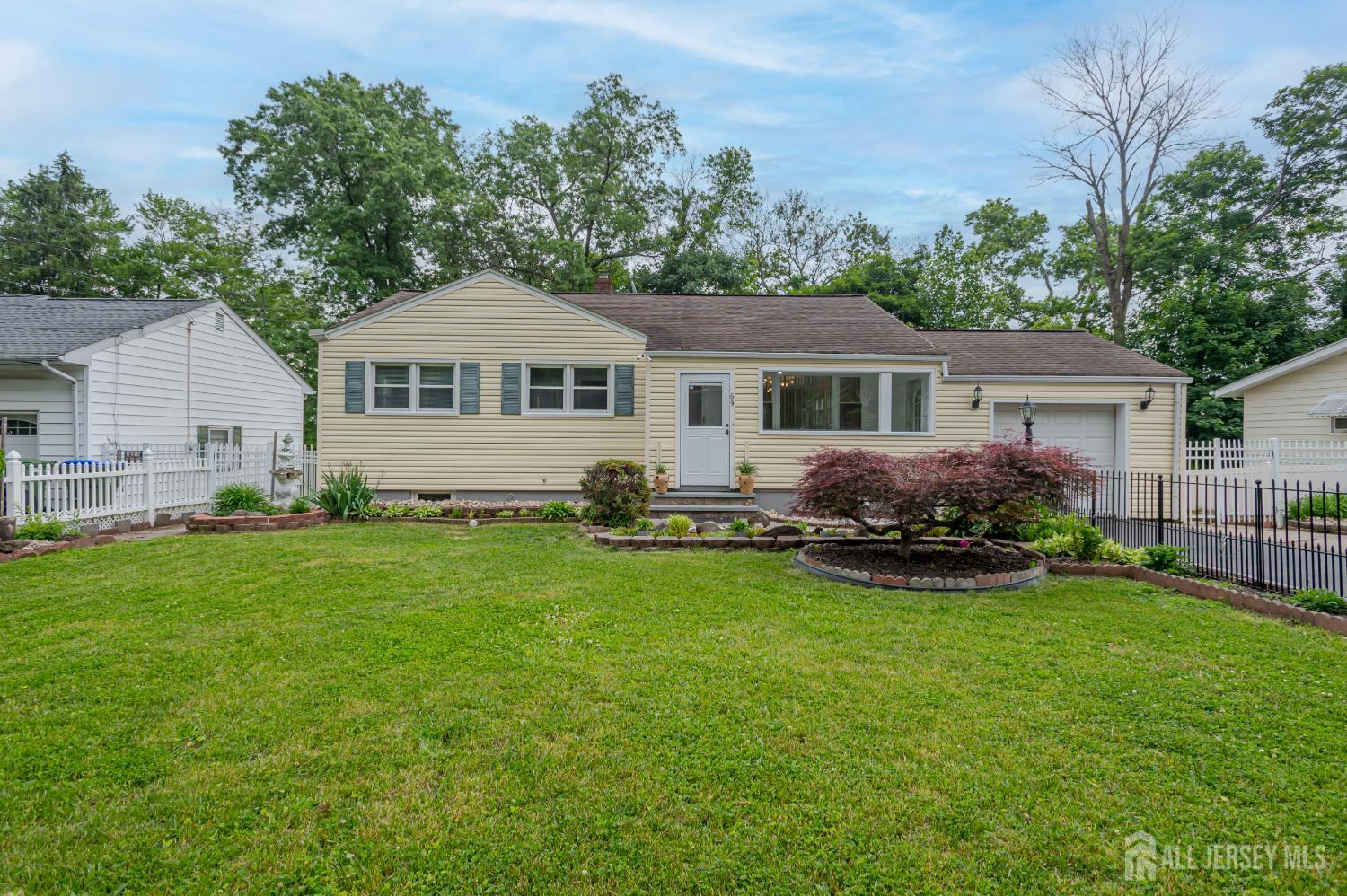 This conveniently located North Edison ranch is close to Metro Park train station, major highways, restaurants and malls! The enclosed front porch welcomes you with a large picture window, tile flooring, and convenient access to the garage, creating a versatile bonus space ideal for a sunny all-season sitting room or mudroom. Step into the bright and inviting living room featuring hardwood floors and an oversized window that fills the space with natural light. The dining room is open to the living area, creating a functional layout perfect for both everyday living and entertaining. The kitchen showcases granite counters, stainless steel stove, dishwasher, and refrigerator, along with plenty of wood cabinets. A door in the kitchen leads to the generous sized backyard featuring an extended paver patio with pergola  an ideal setting for outdoor dining, relaxing, or hosting gatherings. The full bath provides a glass-enclosed shower/tub combination, tiled walls with decorative inlay, oversized vanity, and recessed lighting. The primary bedroom features hardwood flooring, multiple windows, and a modern ceiling fan with lights. Two additional bedrooms also offer hardwood floors, ample closet space, and excellent natural light. Top rated North Edison school system!